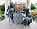Spätere Ausgestaltung mit einer Bronzegruppe am Fuß der Grabstele: zwei Knaben als Bildträger eines Medaillons für Borsigs Ehefrau Luise, gest. 1887 (Zustand um 2014)