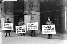 Members of the SA picketing in front of a Jewish place of business with placards saying "Germans! Defend yourselves! Don't buy from Jews!" during the Nazi boycott of Jewish businesses, 1 April 1933 Bundesarchiv Bild 102-14469, Berlin, Boykott-Posten vor judischem Warenhaus.jpg