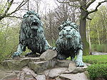 Bronslejon framför Alfred-Brehm-Haus i Tierpark Berlin