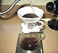 Image 6In a pour-over, the water passes through the coffee grounds, gaining soluble compounds to form coffee. Insoluble compounds remain within the coffee filter. (from Coffee preparation)
