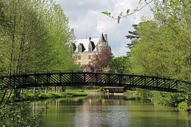 Photographie en couleurs d'une passerelle métallique enjambant un cours d'eau.