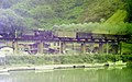 รถจักรไอน้ำโมกุล C56 ไม่ทราบหมายเลข กำลังลากรถสินค้าข้ามสะพานชิมาเนะ ในเส้นทางโกสึ ใน พ.ศ. 2517