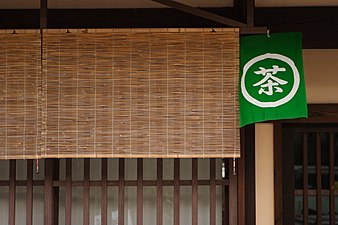 Sudare shading the koshi (wooden lattice) of a teahouse; the sign says "Tea".