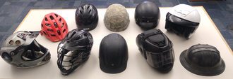 A table with ten different types of helmets
