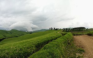 Sich nähernde Regenwolken über einer Weidelandschaft in Masisi in Nord-Kivu