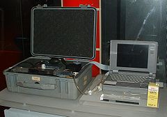 A machine that can facilitate euthanasia through heavy doses of drugs. It is possible in this image to see the laptop screen that leads the user through a series of steps and questions, to the final injection, which is done by motors controlled by the computer. This series of questions is supposedly to prevent unprepared users from undergoing Euthanasia.