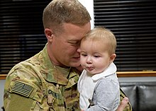 A baby being hugged by a soldier Georgia National Guard (38100696265).jpg