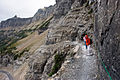 Escursionisti sulla sezione Garden Wall del percorso Highline, a nord del passo di Logan: la via Going-to-the-Sun appare in basso