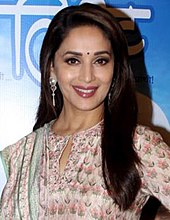 Madhuri Dixit menatap ke arah lain dengan senyum terlukis pada wajahnya.