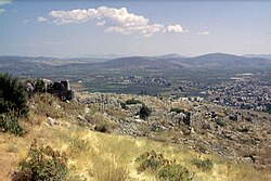 Antiikin Orkhomenoksen kaupungin raunioita, taustalla nykyinen Orchomenós.