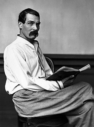 Photographie en noir et blanc d'un homme assis à la moustache fournie