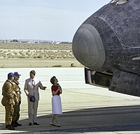 "President Ronald Reagan chats with NASA astronauts Henry Hartsfield and Thomas Mattingly on the runway as first lady Nancy Reagan scans the nose of Space Shuttle Columbia following its Independence Day landing at Edwards Air Force Base on July 4, 1982."[18]
