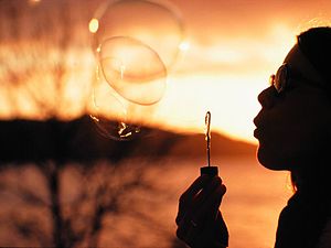 English: Blowing large soap bubbles at sunset