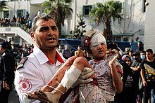 Medic carrying wounded Palestinian child in Gaza Fars Photo of Casualties in Gaza Strip during 2023 War 26.jpg