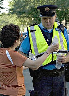 A Hamilton Police Auxiliary Constable receives water from a local storeowner on a hot summer's evening. Hamilton Police Auxiliary Constable.jpg