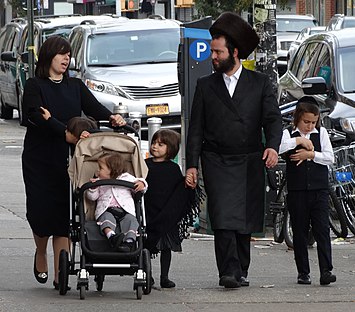 Hasidijuutalainen perhe. Hasidismi on yksi viidestä nykyisestä juutalaisuuden pääsuuntauksesta. Hasidimiehet pukeutuvat usein mustaan takkiin, valkoiseen paitaan ja mustaan lierihattuun. Heillä on myös usein pitkät hiuskiehkurat ohimoillaan.