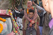 Procession of Nepali Hindu wedding; groom being carried by a helper Nepali Hindu Wedding (34).jpg