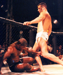 A "soccer kick", movement where the fighter kicks the head of a downed opponent. While common in vale tudo, early MMA and Japanese promotions, the soccer kick has been banned from the Unified Rules of Mixed Martial Arts Pentagon Combat 2.png