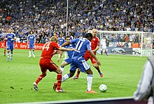 Didier Drogba (blue, no. 11), who often played as a target forward throughout his career, was known for his ability to hold up the ball, as demonstrated during the 2012 UEFA Champions League final against Bayern Munich. Tymoshchuk Drogba.jpg