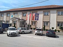 antaŭ la administrejo samrange flirtas la flagoj de Albanio, Turkio kaj Nord-Makedonio