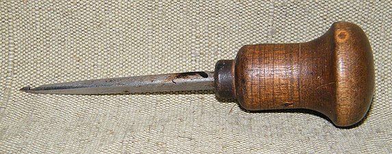 Photographie d'un crochet de couture renforcé avec une poignée en bois.