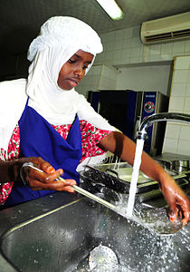 Arta Culinary School student washes dishes after the exchange of homemade recipes. Arta, Djibouti