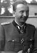 Portrait photo noir et blanc en extérieur d'un homme souriant en uniforme allemand.