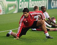Jogador de futebol Luis Suárez se alongando antes de uma partida.