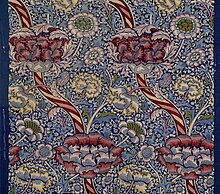 Section of "Wandle" fabric, a complex floral design in white, yellow, and shades of red and pink on a blue and white background.