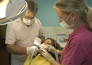English: Dentist drilling a girls tooth