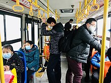 Most people on a bus wearing a mask, Hubei province, 23 January 2020. 2020-1-23 Hu Bei Huang Gang Huang Zhou Qu De Yi Ge Gong Jiao Che Shang .jpg