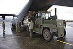 En Svetruck från Norges försvarsmakt som hjälper till att lasta en C-130J Super Hercules från USA:s marinkår.