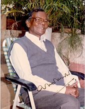 A photograph of a man sitting in the chair