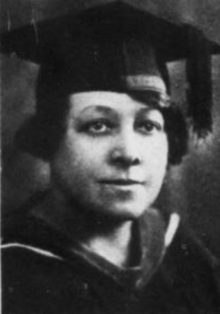 A young Black woman wearing an academic mortarboard cap