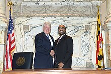 Busch stands next to Sydnor at the Speaker's desk in the Maryland House of Delegates