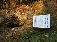 峠頂部にある「上根峠と断層」説明板。簸ノ川の堆積作用によって形成された河床礫層[13]であり、角の取れた粒径の揃った礫が露出している。