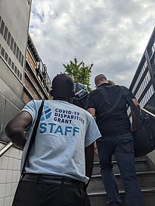 A staff member of the COVID-19 Disparities Grant program exits the subway in Brooklyn, within New York City. COVID-19 Disparities Grant.jpg