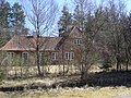 Brick house with overgrown shrubs blocking its view