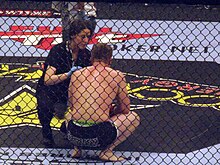 A ring-side doctor attends to a fighter following a loss. Strikeforce trainer 2010-01-07.jpg