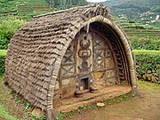 An oval-roofed hut of the Toda people of the Nilgiris. The walls are made of dressed stone and decorated with mural painting