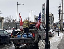 A protester with Canadian and American flags loads up on supplies in Ottawa 2022 Ottawa convoy supply truck.jpg