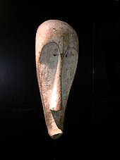 Ngil mask from Gabon or Cameroon; wood colored with kaolin (chiny clay); by Fang people; Ethnological Museum of Berlin. Worn with full costume in a night masquerade to settle disputes and quell misbehavior, this calm visage was terrifying to wrong-doers Fang Ngil Berlin IIIC6000.jpg