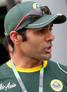 Photographie de profil, d'un homme de type indien, en gros plan, avec des vêtements vert foncé.