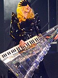Photo de Lady Gaga jouant du keytar dans une tenue de cuir.