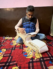 Priest Searching for a Family's ancestory record in a register (vahi), 2023 Photograph.jpg