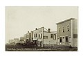 Postcard of Reston, Manitoba: Main street in town with several horse-drawn carts parked along the street. Buildings included are "Dr. Stevenson D.V.S.", "Royal Restaurant", "Imperial Restaurant" and "Harness Shop."