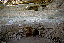 Vue de murs antiques avec une ouverture voûtée en plein cintre.