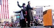 Obama stands on stage with his family. They wave.