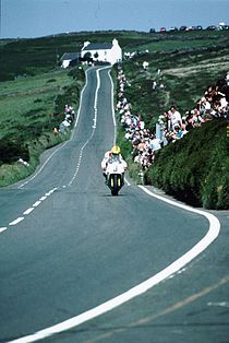 Joey Dunlop remt aan voor Creg-ny-Baa, met Kate's Cottage op de achtergrond. Hij werd in 1992 derde in de Formula One TT