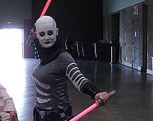 Femme tenant deux représentations de sabres laser